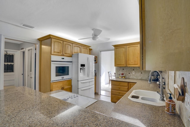 kitchen with ceiling fan, white appliances, sink, backsplash, and light brown cabinets