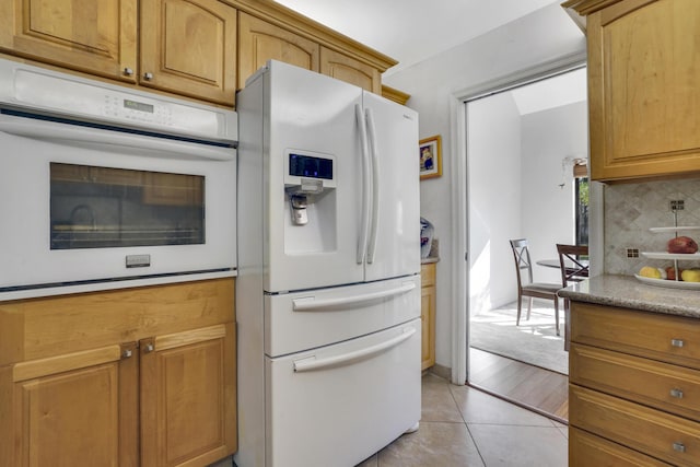 kitchen featuring backsplash, white appliances, and light tile patterned flooring