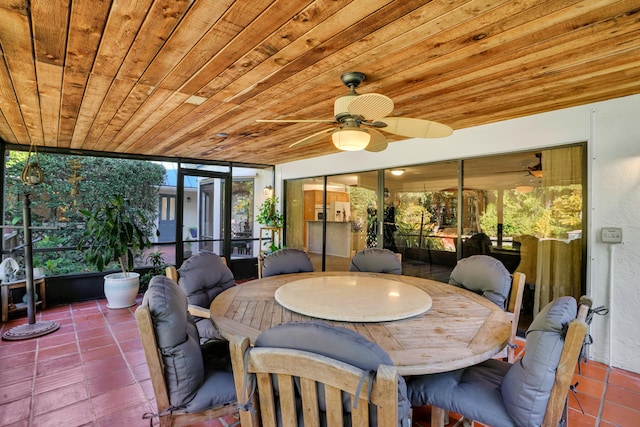 sunroom with ceiling fan and wooden ceiling