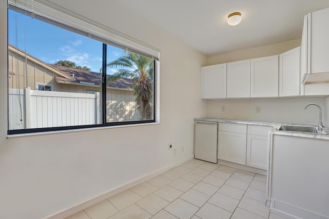 kitchen featuring sink, white cabinetry, and light tile patterned flooring