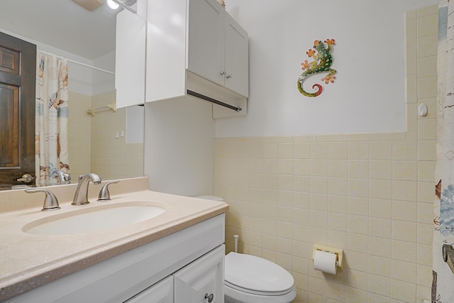 bathroom featuring tile walls, toilet, and vanity