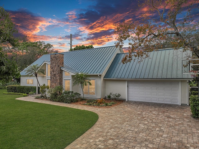 view of front facade with a garage and a yard