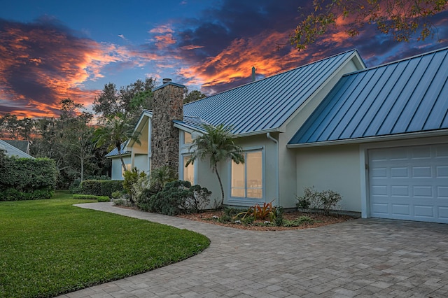 view of front of home with a garage and a lawn