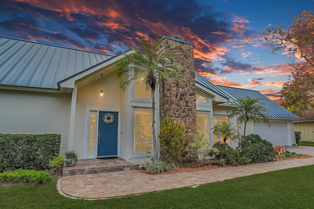 ranch-style house with a garage and a yard