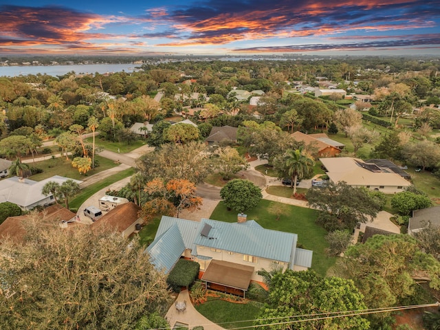 aerial view at dusk featuring a water view