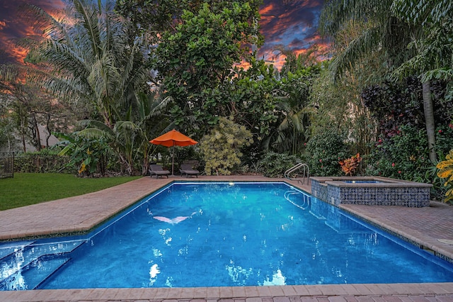 view of pool featuring an in ground hot tub, a patio area, and a yard