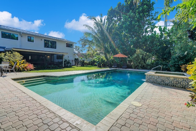 view of swimming pool with an in ground hot tub, a patio area, and a yard