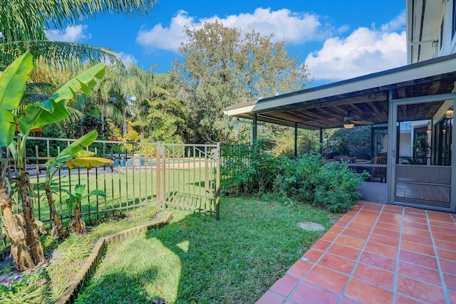 view of yard with ceiling fan and a sunroom