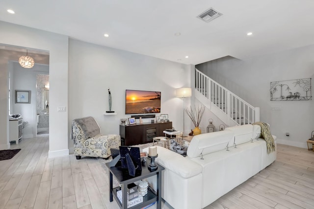 living room featuring a chandelier and light wood-type flooring