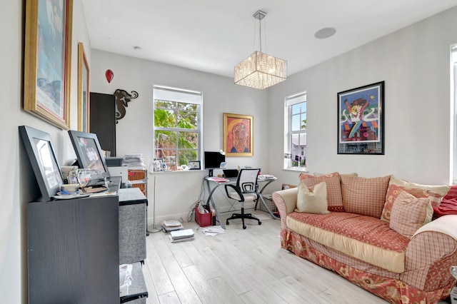 office space featuring light hardwood / wood-style flooring, a healthy amount of sunlight, and a notable chandelier