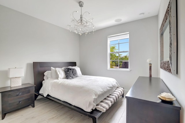 bedroom with a notable chandelier and light hardwood / wood-style flooring