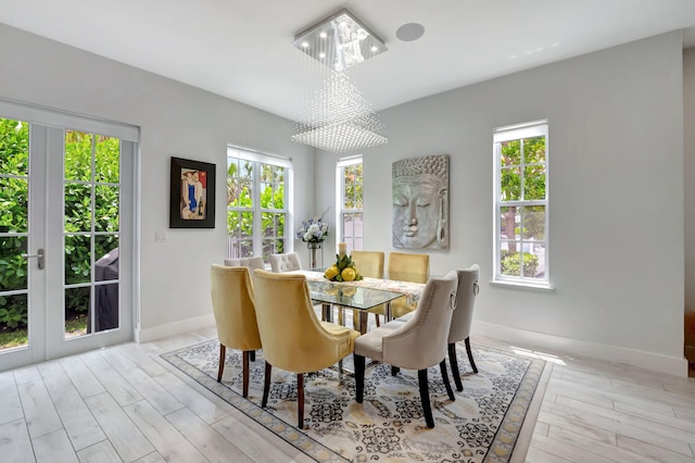 dining room with light hardwood / wood-style floors and a notable chandelier