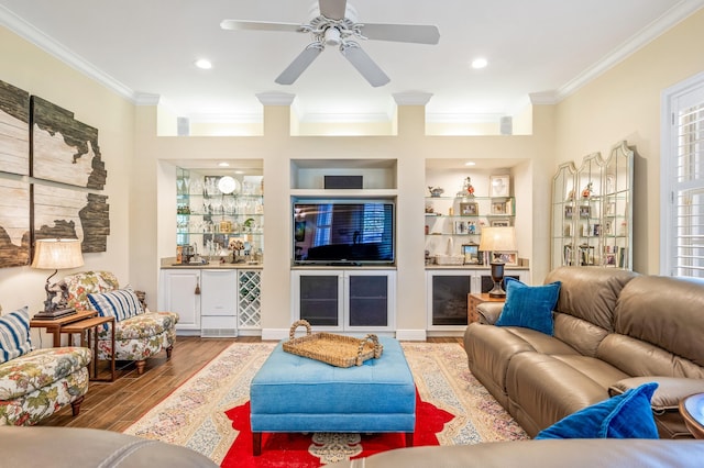 living room with hardwood / wood-style flooring, ceiling fan, built in features, and ornamental molding