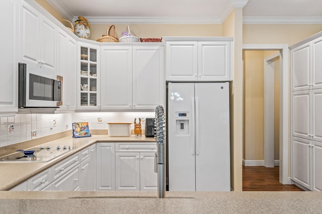 kitchen featuring backsplash, white appliances, crown molding, wood-type flooring, and white cabinets