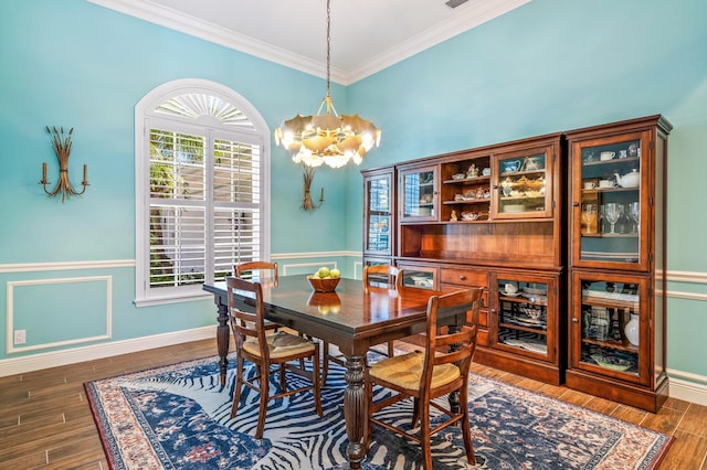 dining space with a healthy amount of sunlight, dark wood-type flooring, crown molding, and a notable chandelier