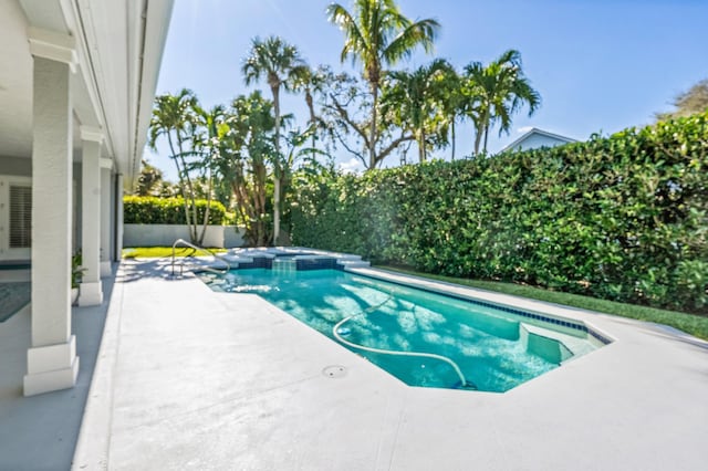 view of swimming pool featuring an in ground hot tub and a patio