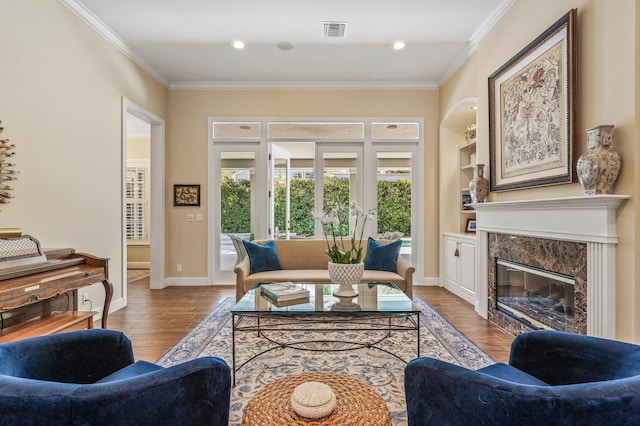 living room featuring a premium fireplace, crown molding, and light hardwood / wood-style flooring