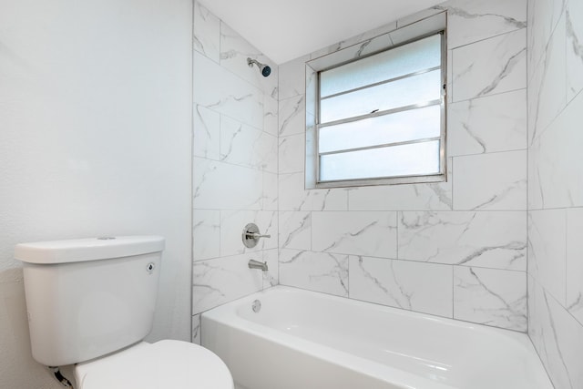 bathroom with tiled shower / bath combo and toilet