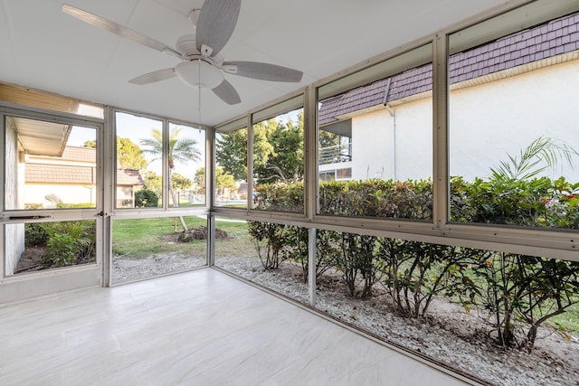 unfurnished sunroom with ceiling fan