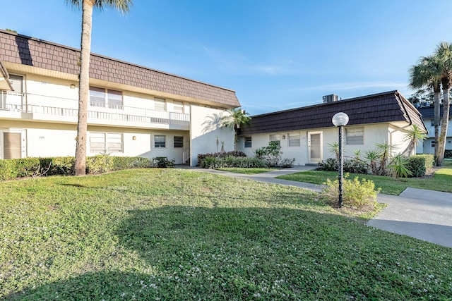 exterior space featuring central AC unit and a front yard