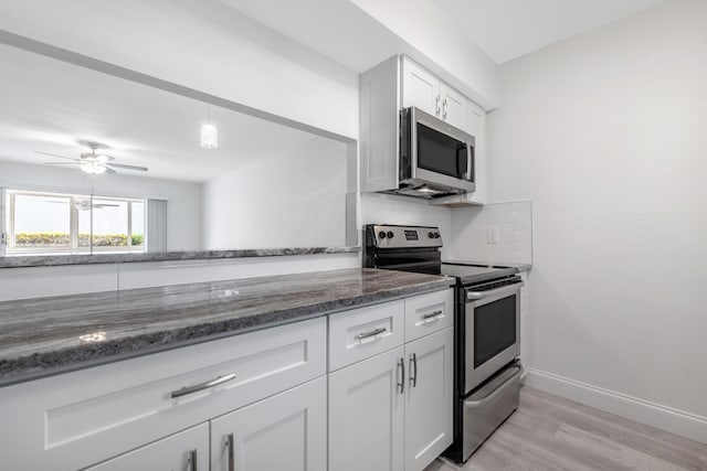 kitchen with ceiling fan, white cabinetry, stainless steel appliances, and tasteful backsplash