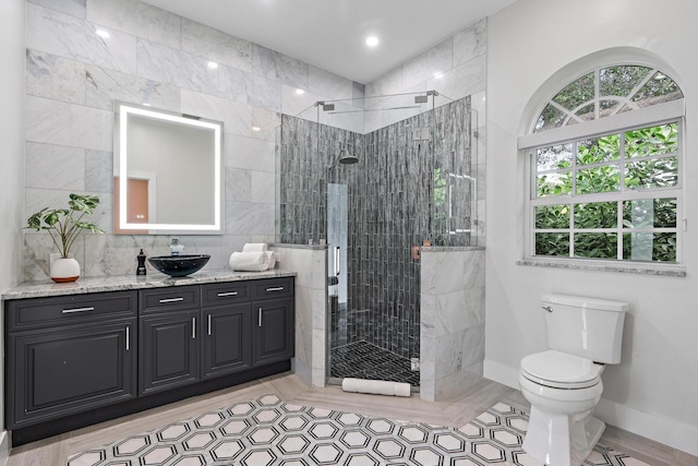 bathroom featuring vanity, toilet, and a shower with door