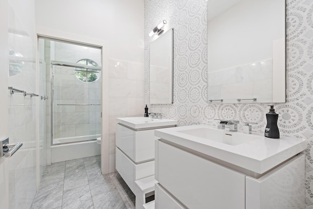 bathroom featuring vanity, toilet, a shower with door, and tile walls