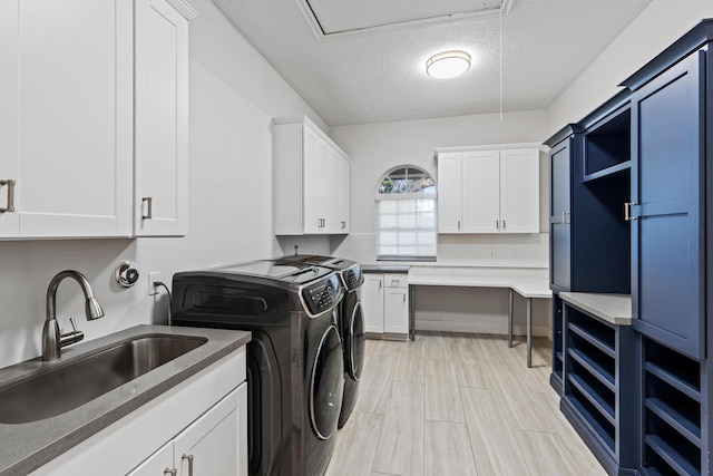 laundry area with cabinets, independent washer and dryer, a textured ceiling, and sink