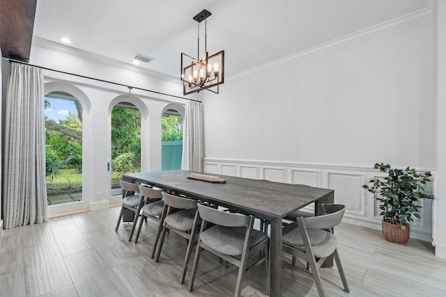 dining room with ornamental molding and a notable chandelier