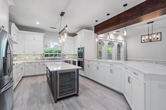 kitchen featuring white cabinets, a kitchen island, and hanging light fixtures