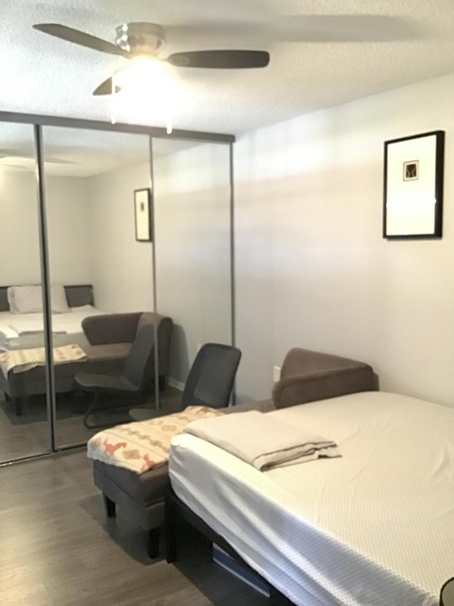 bedroom with wood-type flooring, a textured ceiling, a closet, and ceiling fan