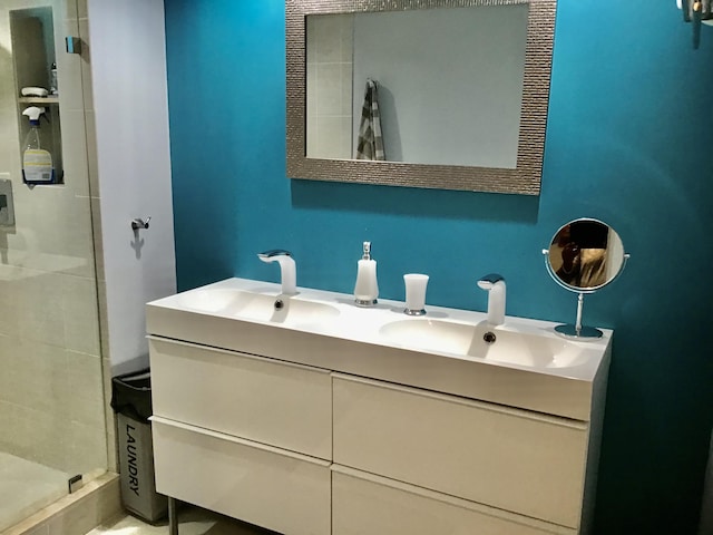 bathroom featuring tiled shower and vanity