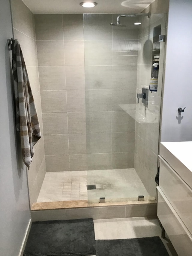 bathroom with tiled shower and vanity