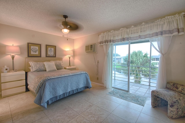 bedroom with ceiling fan, an AC wall unit, a textured ceiling, access to outside, and light tile patterned floors