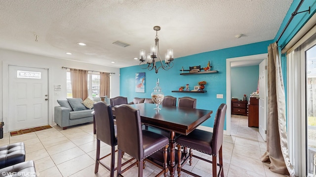 dining room featuring light tile patterned floors, a chandelier, and a textured ceiling