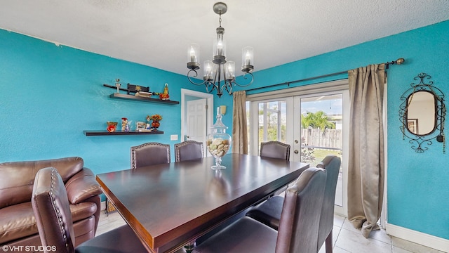 tiled dining space featuring a textured ceiling, french doors, and a notable chandelier