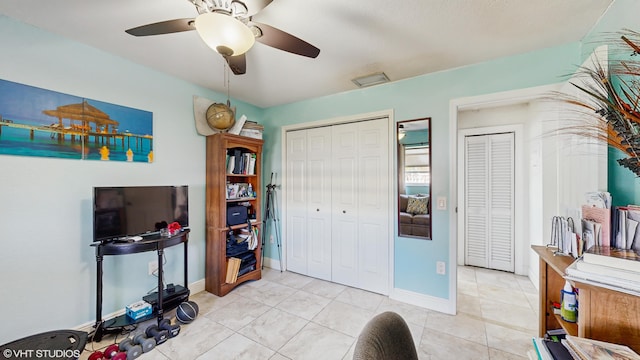 tiled bedroom featuring ceiling fan