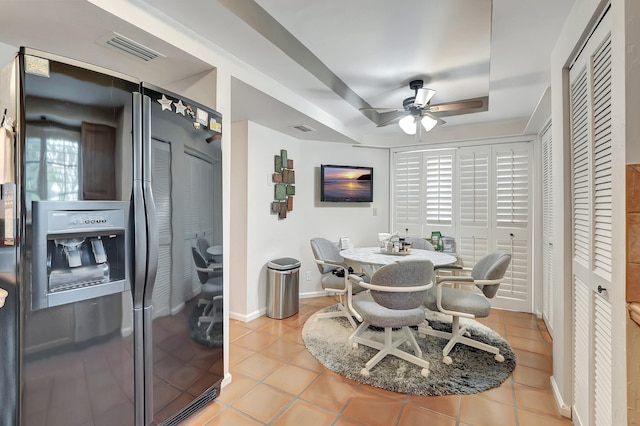 dining room with ceiling fan, light tile patterned floors, and a tray ceiling