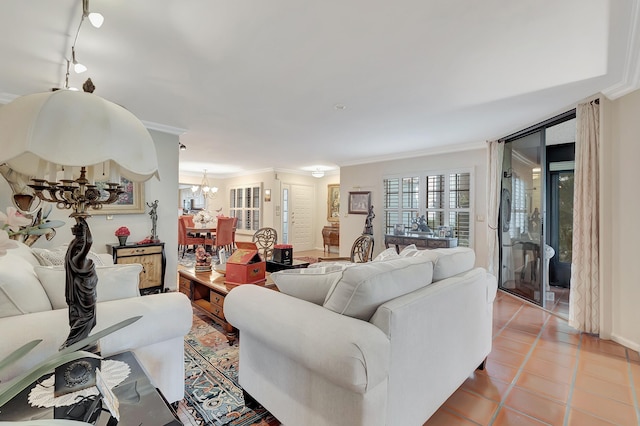 living room with light tile patterned flooring, ornamental molding, rail lighting, and an inviting chandelier