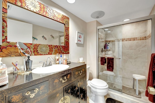 bathroom featuring vanity, toilet, and a shower with shower door