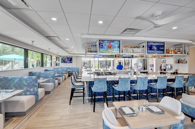 bar with light stone countertops and decorative light fixtures