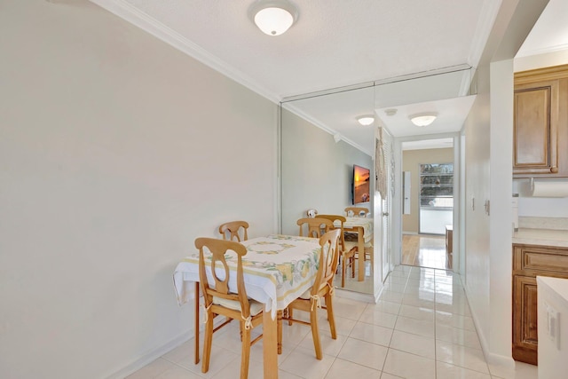 dining space featuring light tile patterned floors, a textured ceiling, and ornamental molding