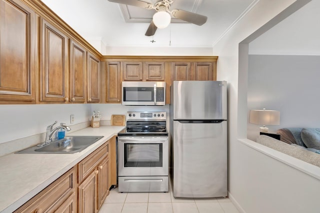 kitchen with sink, ceiling fan, ornamental molding, light tile patterned flooring, and stainless steel appliances