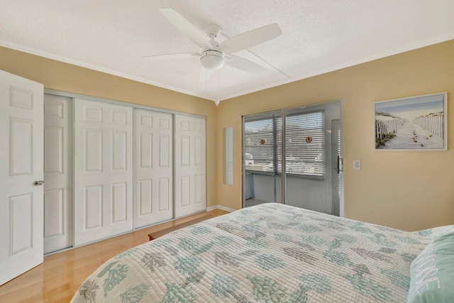 bedroom with ceiling fan, hardwood / wood-style floors, and a textured ceiling