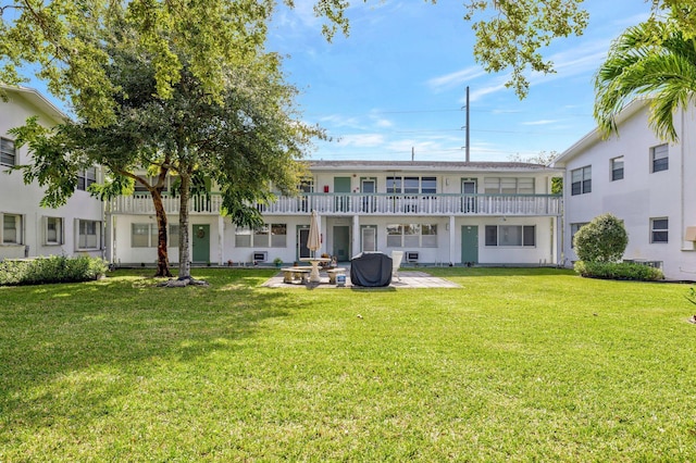 rear view of house with a lawn and a patio area