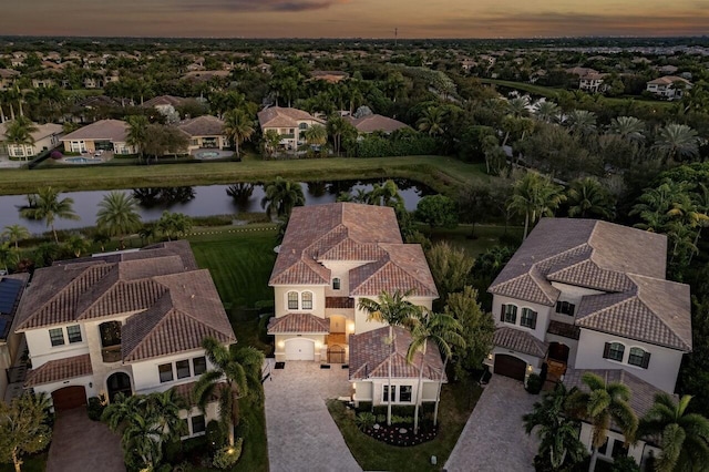 aerial view at dusk featuring a water view