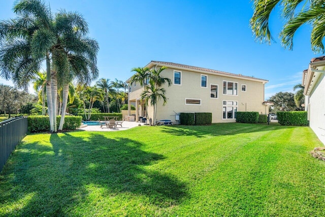 back of house with a lawn, a fenced in pool, and a patio