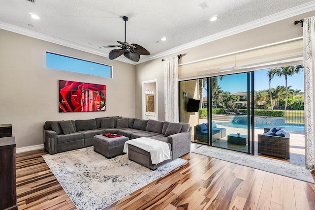 living room featuring ceiling fan, crown molding, a healthy amount of sunlight, and hardwood / wood-style flooring