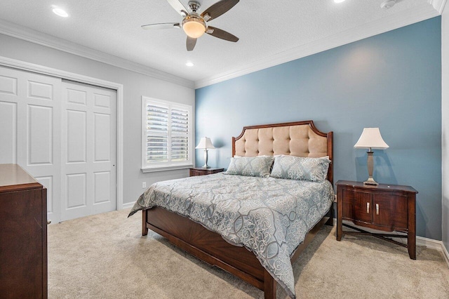 carpeted bedroom with a closet, ceiling fan, and crown molding