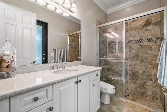 bathroom featuring vanity, toilet, a shower with door, and crown molding